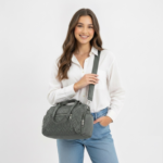 Green CROSSLAND quilted duffel bag with black handles, detachable shoulder strap, and multiple silver zippered pockets, shown against a white background.