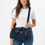 Navy blue CROSSLAND quilted duffel bag with black handles, detachable shoulder strap, and multiple silver zippered pockets, shown against a white background.