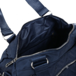 Navy blue CROSSLAND quilted duffel bag with black handles, detachable shoulder strap, and multiple silver zippered pockets, shown against a white background.